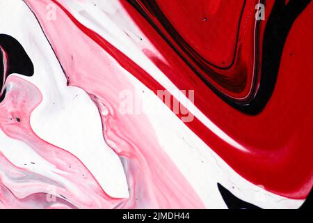 Marmoriertes Acrylfarbenmuster in den Farben rot, schwarz, weiß und pink. Stockfoto