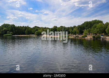 Senftenberg, Deutschland. 04. August 2022. Der Badestrand befindet sich neben dem Stadthafen des Senftenberger Sees, der 2013 eröffnet wurde. Der künstliche See wurde bis 1972 durch die Überflutung einer ehemaligen Braunkohlemine im Tagebau geschaffen und ist bis zu 25 Meter tief. Als Naherholungsgebiet ist der See bei Touristen sehr beliebt. (To dpa survey 'Tourist Areas') Credit: Soeren Stache/dpa/Alamy Live News Stockfoto