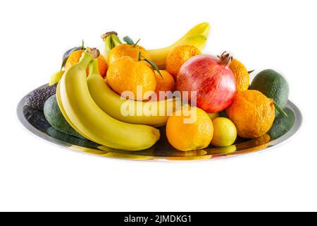 Verschiedene Obst- und Gemüseteller mit Bananen, Granatapfel, Zitrone, Mandarine und Avocado. Stockfoto