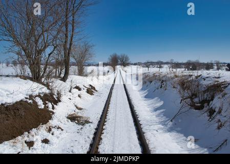 Die Bahn führt durch die schneebedeckte Landschaft Stockfoto