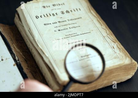 Vintage historischen Buch geöffnet und Lupe in menschlicher Hand Stockfoto