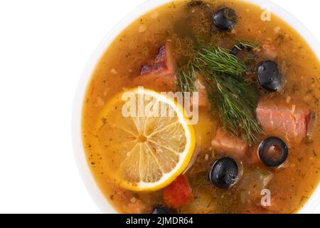 Suppe mit Fleisch, Oliven, Zitrone, Gewürzen und Gewürzen. Isolierte russische Soljanka, hausgemachte Speisen. Draufsicht Stockfoto