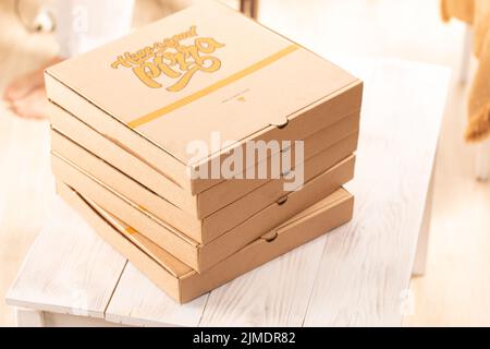 Pizzakarton, Stapel, braun, Vorderansicht. Auf dem Esstisch Stockfoto