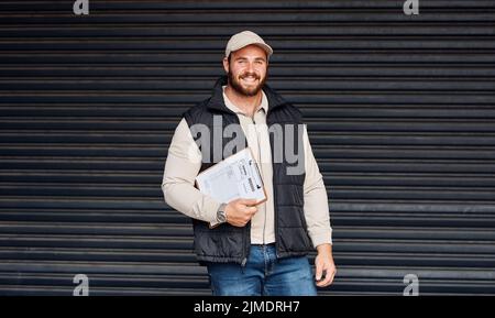 Wir arbeiten hart daran, einen effizienten Service zu bieten. Porträt eines Kuriers mit einem Klemmbrett. Stockfoto