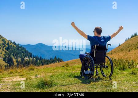 Optimistisch behinderten Mann sitzt auf Rollstuhl Stockfoto