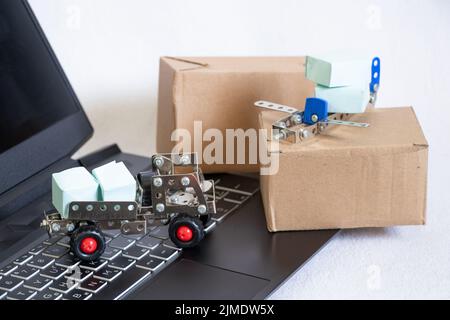 Versand-, Liefer- und Logistikkonzept. LKW- und Flugzeug- und Pappkartons auf Laptop-Tastatur. Online-Technologien. Online-Lieferung von Waren, courie Stockfoto