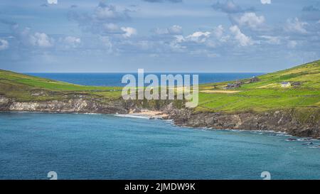 Touristen entspannen sich am kleinen versteckten Coumeenoole Beach zwischen Klippen in Dingle Stockfoto