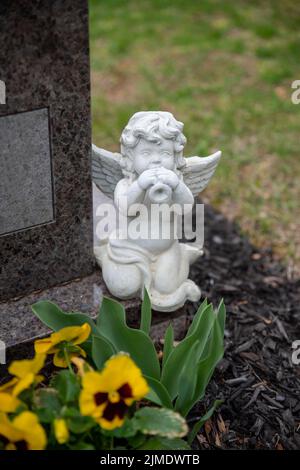 Der Engel des Friedhofs spielt die Trompete auf einem Grabstein Stockfoto