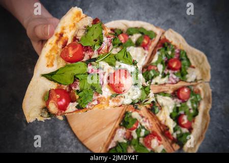 Pizza mit Käse, Tomaten, Spinat und Räucherwurst Stockfoto