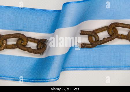 Gebrochene Ketten auf der argentinischen Flagge. Konzept der Revolution und der nationalen Unabhängigkeit Stockfoto