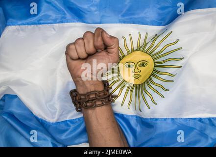 Fäuste, die die Ketten auf der argentinischen Flagge brechen. Argentinische Revolution und Unabhängigkeitskonzept Stockfoto