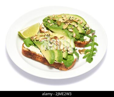 Frisch zubereitete Avocado- und Frischkäse-Toasts isoliert auf weißem Hintergrund Stockfoto