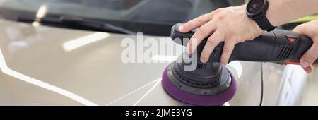 Männliche Hände polieren die Motorhaube eines Fahrzeugs Stockfoto