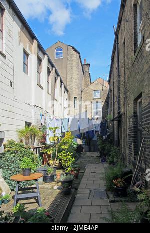 Hintergasse zwischen Straßen mit Reihen von traditionellen Steinhäusern in hebden Bridge West yorkshire mit Waschen Trocknen an Linien und Stockfoto