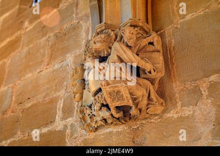 Biblische und bäuerliche Aktivitäten Schnitzereien im Zusammenhang mit der Weinlese auf dem romanischen Portal der Festungskirche Iglesia de Santa Maria in Ujue, Spanien Stockfoto