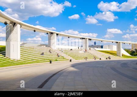 Die Menschen entspannen sich in einem modernen Erholungsgebiet inmitten abstrakter architektonischer Formen Stockfoto