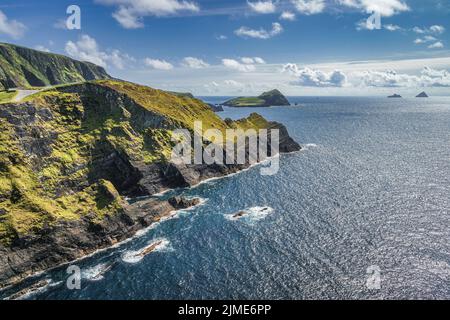 Hohe Kerry Cliffs und ein Blick auf die Silhouette der Skellig Michael Insel in der Ferne Stockfoto