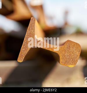 Nahaufnahme des Querschnitts einer rostigen Eisenbahnschiene in einem Lagerplatz Stockfoto