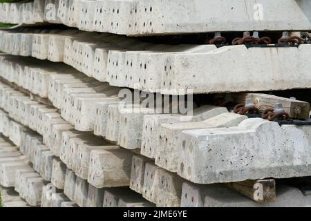 Neue Beton-Eisenbahnschweller auf dem Lagerplatz einer Baustelle Stockfoto