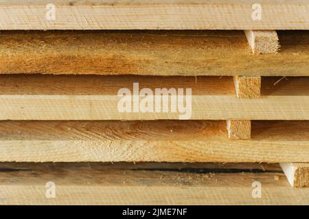 Bretter und Bauholz liegen in der Schreinerei. Holzbearbeitung. Hintergrund für den Produktlieferanten. Stockfoto