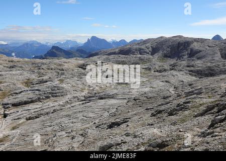 Hochplateau, das wie eine Mondlandschaft aussieht, mit dem gepflasterten Felsen auf den Dolomiten und der Alpenhütte Stockfoto
