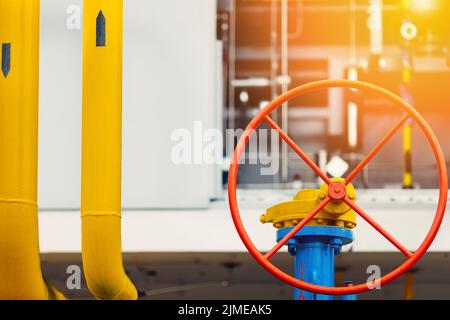 Nahaufnahme des runden roten Ventils. Industrieller Hintergrund. Vergasung oder Transport von Erdgas. Stockfoto