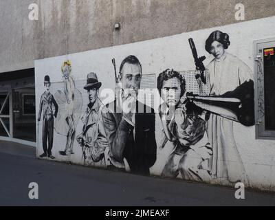 Ein schwarz-weißes Graffiti auf der Pali Cinema Wall mit Marilyn Monroe, Charlie Chaplin, James Bond, Humphrey Bogart in Darmstadt, Deutschland Stockfoto