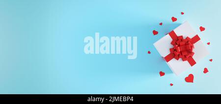 Weiße Geschenkbox mit roter Schleife auf hellblauem Hintergrund mit Herz-Konfetti. Weihnachtsgeschenk, valentinstag Überraschung, birt Stockfoto