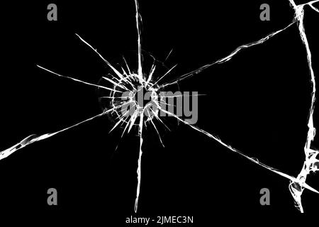 Textur von Rissen auf dem Glas aus dem Schuss. Gesprungenes Glas für das Design. Risse auf schwarzem Hintergrund Stockfoto