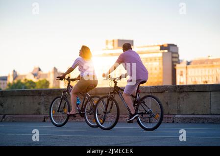 Reifes Paar, das in der Stadt Fahrräder fährt Stockfoto