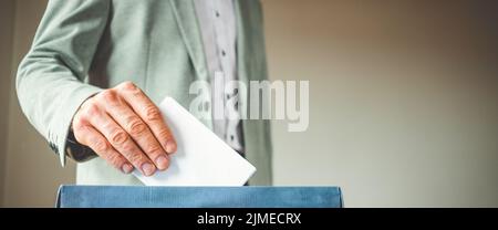 Männliche Hand, die die Stimme in die Abstimmung einbringt Stockfoto