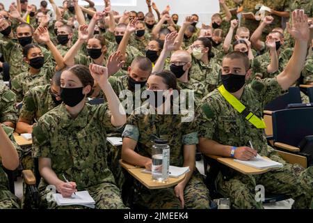 Great Lakes, Illinois, USA. 3. August 2022. Naval Reserve Officers Training Corps (NROTC) New Student Indoctrination (NSI) 2022 Zyklus 3 Midshipman heben ihre Hände während einer Ausbildung zum Kleinwaffenschützer beim Recruit Training Command (RTC). Nach Abschluss des NSI beginnen die Kandidaten im Herbst an Hochschulen und Universitäten bundesweit ihr Neubeginnjahr des NROTC-Programms. NSI ist ein Indoktrinationsprogramm, das am RTC ausgerichtet wird und Midshipmen eine gemeinsame militärische Ausbildungsorientierung bietet. NSI bietet eine Grundausbildung in fünf Grundlagen der Kampfhandlungen C Brandbekämpfung, Schadensbekämpfung an Stockfoto