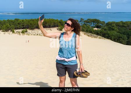 Eine italienische Touristin fotografiert sich auf der Dune du Pilat. Wiedereröffnung der Dune du Pilat und ihrer Touristen nach dem Brand. Frankreich, Le-Pyla-sur Mer, La Teste-De-Buch. 4. August 2022. Foto von Patricia Huchot-Boissier/ABACAPRESS.COM Stockfoto