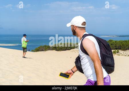 Ein Mann macht ein Foto auf der Düne mit Blick auf das Becken. Wiedereröffnung der Dune du Pilat und ihrer Touristen nach dem Brand. Frankreich, Le-Pyla-sur Mer, La Teste-De-Buch. 4. August 2022. Foto von Patricia Huchot-Boissier/ABACAPRESS.COM Stockfoto