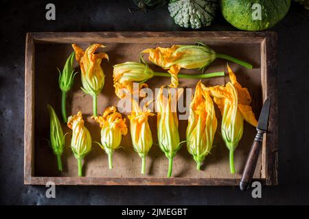 Vorbereitung für gebratene Kürbisblüte aus Pfannkuchenteig. Frittierte gelbe Zucchini-Blüten. Stockfoto