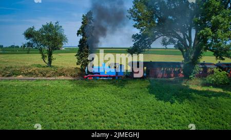 Luftaufnahme von Thomas, dem Tank-Motor, der sich nähert, und von Pkw, die Rauch aufbläst, zieht Stockfoto