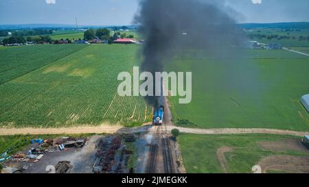 Luftkopf mit Blick auf Thomas, den Panzermotor, der sich durch Bäume und Ackerland nähert Stockfoto