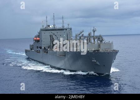 Philippinische See. 4. August 2022. Das militärische Sealift Command Lewis und Clark-Klasse Trockenfrachtschiff USNS Carl Brashear (T-AKE 7) nähert sich dem militärischen Sealift Command Henry J. Kaiser-Klasse unterwegs Nachschuböler USNS Tippecanoe (T-AO 199) während des Betriebs in der philippinischen See, August. 2, 2022. Das Militär-Sealift-Kommando Far East stellt sicher, dass rund 50 Schiffe in der Indo-Pazifik-Region, darunter Carl Brashear und Tippecanoe, bemannt, geschult und ausgestattet sind, um Kriegsjäger sowohl auf See als auch an Land mit lebensnotwendigen Vorräten, Treibstoff, Fracht und Ausrüstung zu versorgen. Unter Commander, US Pacific Stockfoto