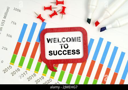 Business- und Economy-Konzept. Es gibt Markierungen, Diagramme und ein Zeichen auf dem Tisch - WILLKOMMEN ZUM ERFOLG Stockfoto