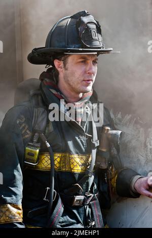 Der Feuerwehrmann Richard Osterberg, Jr. von East Hampton wartet an einem Eingang als Mitglieder der East Hampton Fire Department und der Springs Fire Department ente Stockfoto