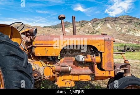 Ein Traktor mit antikem Koffer auf einer verlassenen Farm in den Hügeln von Zentral-Oregon, USA Stockfoto