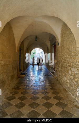 Touristen an einem Durchgang in der Kathedrale des Hl. Quirinus in der Altstadt von Krk in Kroatien Stockfoto