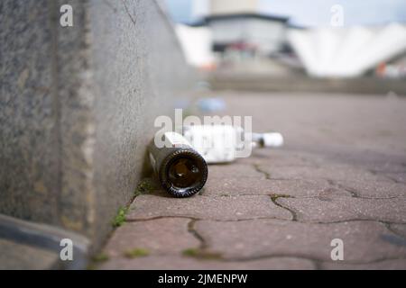 Leere Alkoholflaschen auf einem Bürgersteig am Alexanderplatz im Zentrum Berlins Stockfoto