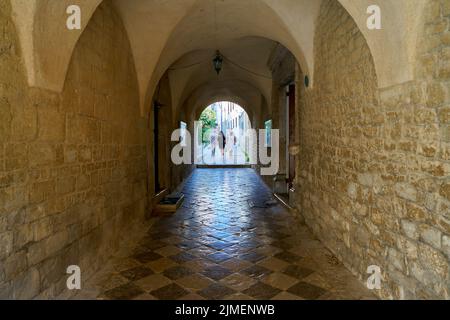 Touristen an einem Durchgang in der Kathedrale des Hl. Quirinus in der Altstadt von Krk in Kroatien Stockfoto