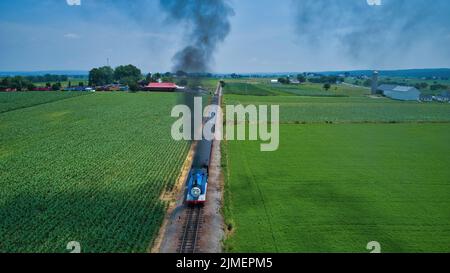 Luftkopf mit Blick auf Thomas, den Panzermotor, der sich durch Bäume und Ackerland nähert Stockfoto