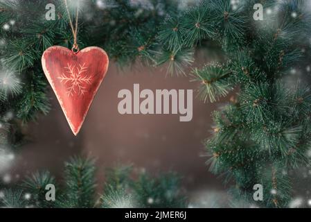Frohe Weihnachten Grußkarte. Rotes Herz weihnachtsbaumschmuck mit Kopierraum. Stockfoto