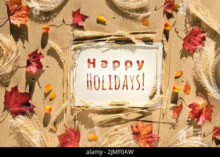 Herbstrahmen, Bildunterschrift Frohe Feiertage. Natürliche Herbstblätter, Weizenohren und Pampagras. Stockfoto