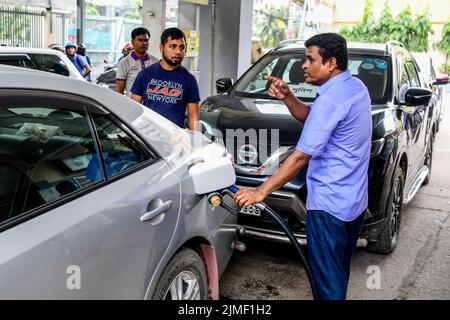 Ein Pumpenwart betankt ein Auto an einer Tankstelle in Dhaka. Die Regierung hat die Ölpreise um 42,5 % auf 51,6 % erhöht, den höchsten Wert seit 20 Jahren, was den Menschen, die bereits von den explodierenden Preisen für lebenswichtige Güter inmitten der Rekordinflation überwältigt sind, einen großen Schlag versetzt. Die Division Energy and Mineral Resources hat am Freitagabend die Diesel- und Kerosinpreise um Tk34 pro Liter auf Tk114 und die Oktan- und Benzinpreise um Tk46 pro Liter auf Tk135 steigen lassen. Die Regierung kündigte die Anhebung zu einer Zeit an, in der die Ölpreise auf dem internationalen Markt im Abwärtstrend sind. Der Rohölpreis von Brent am Freitag betrug 95,50 Dollar pro Barrel. Es ha Stockfoto