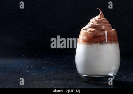 Dalgona kalter Kaffee auf schwarzem Hintergrund mit Kopierplatz Stockfoto