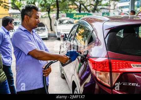 Ein Pumpenwart betankt ein Auto an einer Tankstelle in Dhaka. Die Regierung hat die Ölpreise um 42,5 % auf 51,6 % erhöht, den höchsten Wert seit 20 Jahren, was den Menschen, die bereits von den explodierenden Preisen für lebenswichtige Güter inmitten der Rekordinflation überwältigt sind, einen großen Schlag versetzt. Die Division Energy and Mineral Resources hat am Freitagabend die Diesel- und Kerosinpreise um Tk34 pro Liter auf Tk114 und die Oktan- und Benzinpreise um Tk46 pro Liter auf Tk135 steigen lassen. Die Regierung kündigte die Anhebung zu einer Zeit an, in der die Ölpreise auf dem internationalen Markt im Abwärtstrend sind. Der Rohölpreis von Brent am Freitag betrug 95,50 Dollar pro Barrel. Es ha Stockfoto